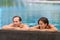 Swimming pool wellness resort couple relaxing sunbathing in infinity luxury retreat pool in hotel. Tropical travel