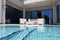 swimming pool with white outdoor furniture on modern luxury resort