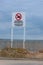 Swimming Prohibited Dangerous Currents warning sign at ocean beach shoreline