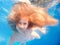 Swimming young girl with long haired underwater in pool