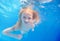 Swimming young girl underwater in pool