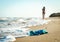 swimsuit in the sand on the beach near the sea surf on the background of a naked female figure and blue sky