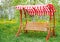 Swing bench near children house in garden.