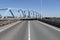 A swing bridge turns at a road in summer