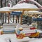 Swing carousel seat in the snow, bright multi-colored attraction under the snow, winter amusement park