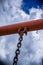 Swing chain detail with blue sky and clouds