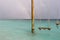 Swing in the ocean, rainbow in the sky after rain on a resort island in the Maldives