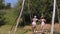 swinging. Happy two girls are having fun swinging together on a big wooden swing, in the park, sunny summer day. Happy