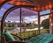 Swinging lounge chair on a lanai at sunset as it overlooks a pond with a fountain