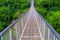 Swinging suspension bridge leading to the cave city of Khndzoresk over a gorge in the mountains