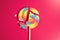 Swirl round broken lollipop on pink background.