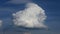 Swirled puffy cloud against a deep blue sky