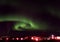 Swirling Aurora Borealis over a Small Town in North Iceland