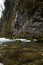 Swirling mountain river flows among rocks covered with green moss and trees