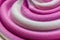 Swirling pink Italian ice cream with a ridged pattern background