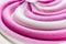 Swirling pink Italian ice cream with a ridged pattern background texture