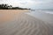 Swirling serpentine sand patterns on Nilaveli Beach with boat in Trincomalee Sri Lanka