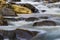 Swirling waters cascading over and around rocks in a mountain stream