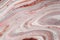 Swirls of marble or the ripples of agate. Liquid marble texture with pink and brown colors. Abstract painting background