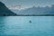 Swiss Alps mountain and Lake Geneva landscape with tourist paddling on the lake in a yellow kayak