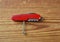 Swiss army red knife on wooden background. Multi-tool