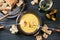 Swiss cheese fondue as new year party meal with bread on long forks, pickles and wine on a dark wooden table, high angle view from