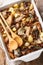 Swiss chicken fricassee with wild mushrooms and potatoes close-up in a baking dish. Vertical top view