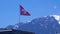 Swiss flag on a background of alpine mountains standing on the roof of the house