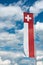 Swiss flag banner under an expressive blue sky with white cumulus clouds and copy space
