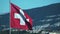 The Swiss Flag flaps in slow motion over Geneva Switzerland