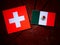 Swiss flag with Mexican flag on a tree stump isolated