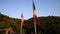 Swiss and French national flags waving at red sunset