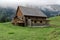 Swiss mountain stable on a green spring meadow with big manure pile in front of the house, manure is good for farming, this house