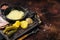 Swiss Raclette Melted cheese with boiled potato and ham on wooden board. Dark background. Top view. Copy space