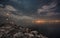 Swiss starry night scene, tranquil lake at night, rocky pier, and the reflection of city lights in the distance in the lake