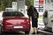 Swiss and traveler people fill oil to tank of car in petrol station