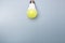 Switched on led bulb with yellow light on grey background with copy space for advert. business idea concept