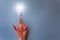 Switched on light bulb on young girl`s hand.