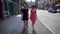 Switzerland, cityscape of Lugano. A pair of young people are walking around the city, Girl in red, Man in black.