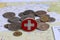 Switzerland flag on the coin with heap of Swiss franc money on the map. Concept of currency or travel