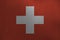 Switzerland flag depicted in paint colors on old brushed metal plate or wall closeup. Textured banner on rough background
