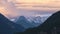 Switzerland snow capped mountain peaks at sunset, with layers of lenticular clouds.