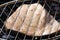 Swordfish steak cooking on barbecue grill closeup