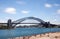 Sydney Harbour Bridge with blurry clouds and water.