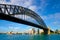 Sydney harbour bridge looking up from under with opera house in distance, blue sky