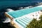 Sydney, NSW/Australia: Bondi Beach with the Iceberg Pool in the background and the surfers