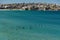 Sydney, NSW/Australia: Bondi Beach with the Iceberg Pool in the background and the surfers