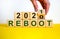 Symbol of 2021 reboot. Businessman changes words \'reboot 2020\' to \'reboot 2021\'.