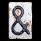 Symbol ampersand made of forged metal on the background fragment of a metal surface with cracked rust.