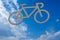Symbol of a bicycle lane on a blue sky with clouds